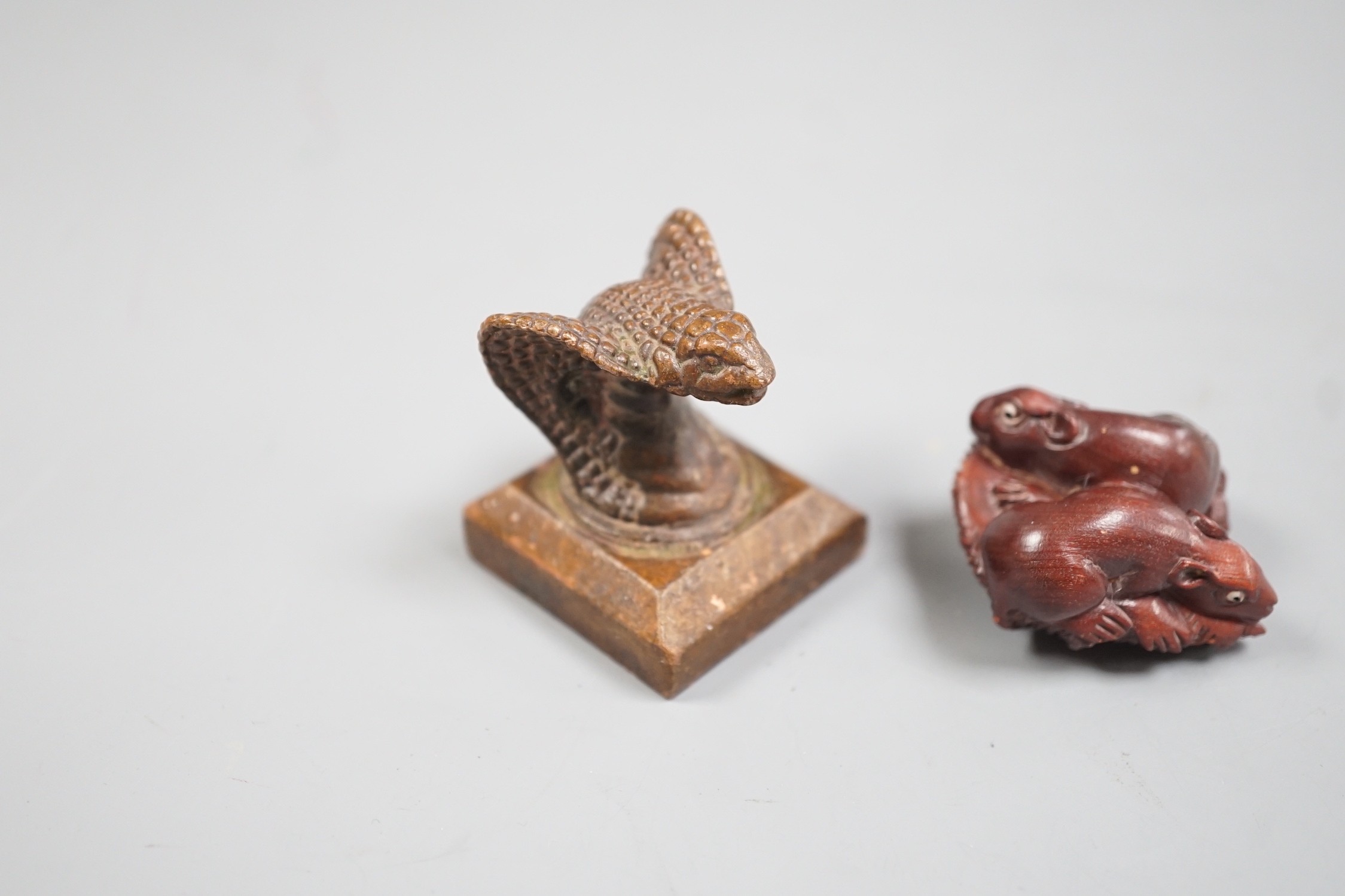 A Chinese bronze 'cobra' seal and a Japanese carved wood netsuke with signed mother of pearl tablet to underside. Seal 4cm tall